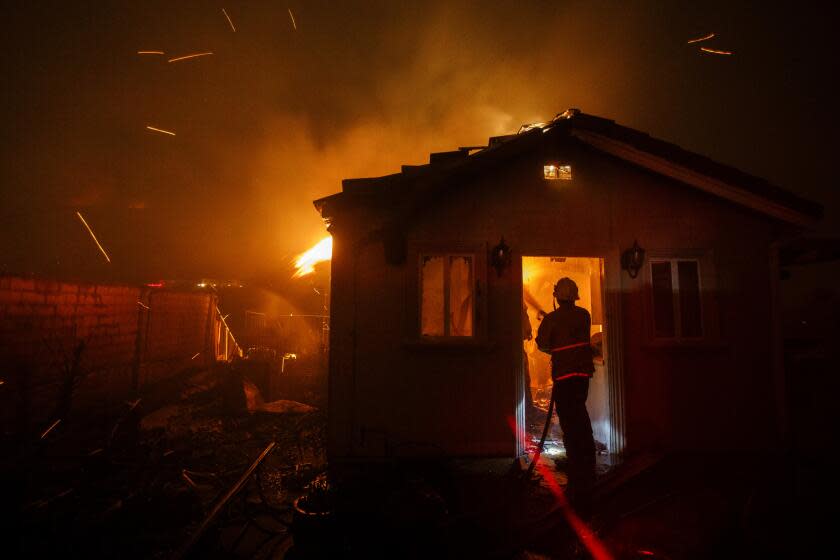 Patrick T. Fallon  For The Times FIRE CREWS enter a house engulfed in flames as the Saddleridge fire spreads quickly early Friday morning.