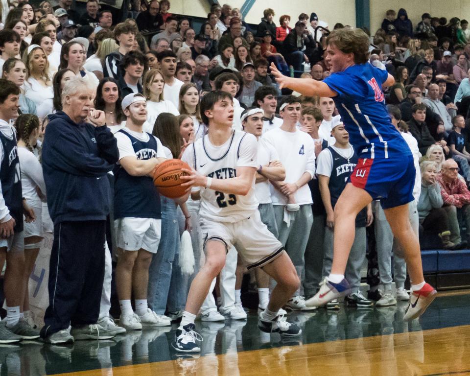 Exeter's Kooper Marier looks to get the ball in-bounds as Winnacunnet's Ethan Nowak defends during Friday's Division I boys basketball game in Exeter.