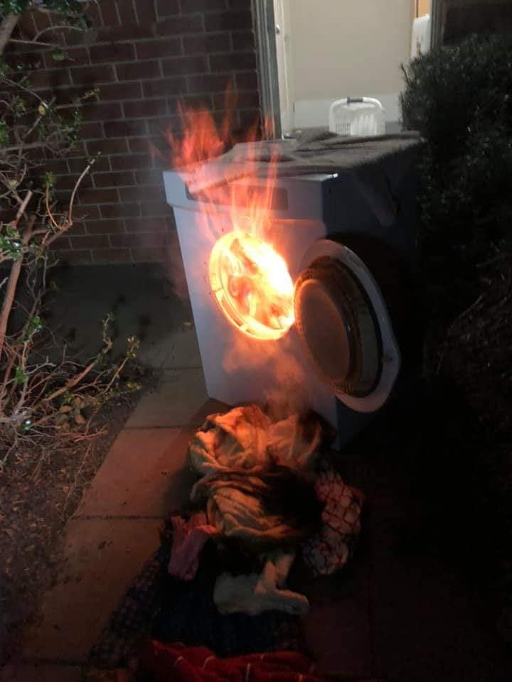 Flames protrude out of the door of a dryer on fire at a Murrumbateman home. 