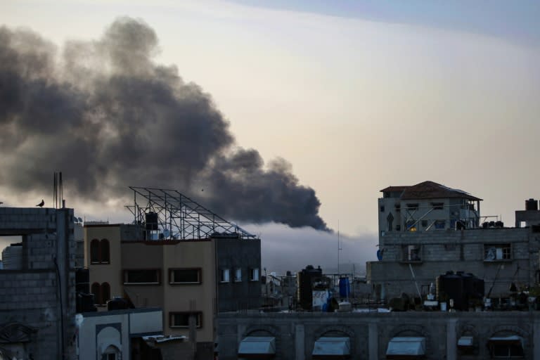 Smoke rises above buildings at sunrise in the aftermath of Israeli bombardment in Rafah in the southern Gaza Strip (-)