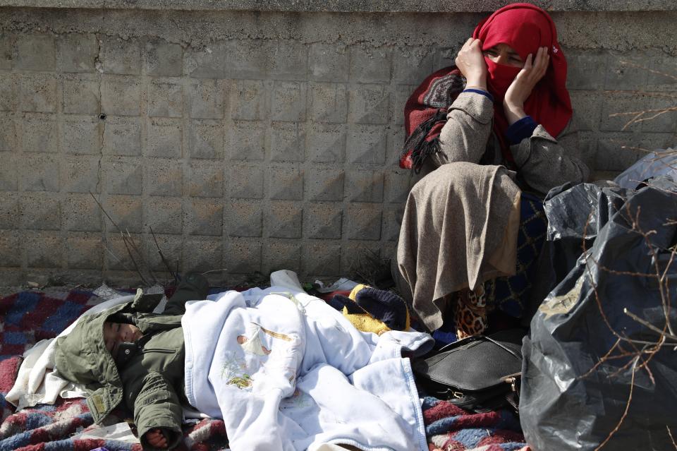 A migrant woman sits as a baby sleeps at an abandoned building in Edirne, near the Turkish-Greek border on Friday, March 6, 2020. Clashes between Greek riot police and migrants attempting to cross the border from Turkey erupted anew Friday as European Union foreign ministers held an emergency meeting to discuss the situation on the Turkey-Greece border and in Syria, where Turkish troops are fighting. (AP Photo/Darko Bandic)