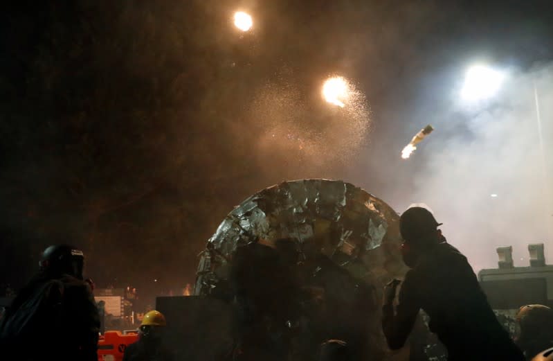 Protesters throw a molotov cocktail during a standoff with riot police at the Chinese University of Hong Kong