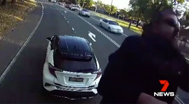 The angry driver hops onto the front of the truck and hurls abuse, which earned him a $2500 fine and a criminal conviction.