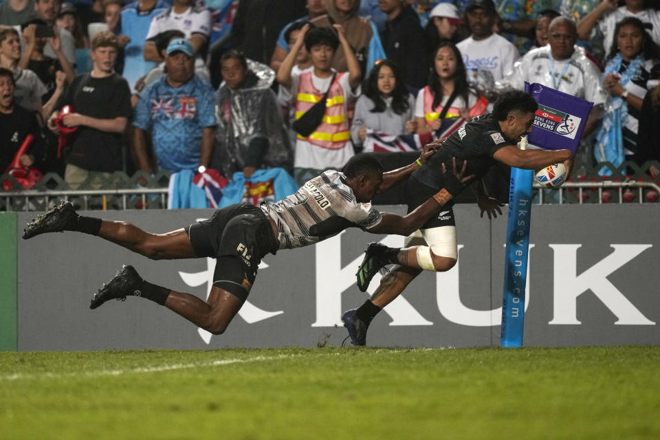 New Zealand's Ngarohi McGarvey-Black dives to score a try as he is tackled by Fiji's Joseva Talacolo during the final match in the Hong Kong Sevens rugby tournament in Hong Kong, Sunday, April 2, 2023. (AP Photo/Louise Delmotte)