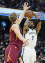 Brooklyn Nets' Kyrie Irving (11) shoots over Cleveland Cavaliers' Lauri Markkanen, left, in the second half of an NBA basketball game, Monday, Jan. 17, 2022, in Cleveland. (AP Photo/Tony Dejak)