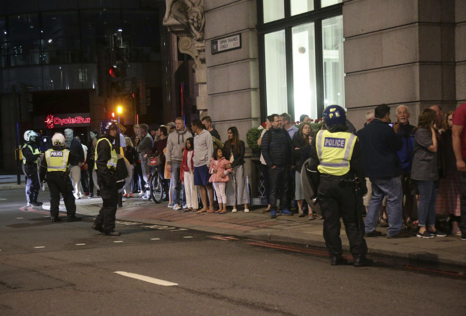 Guests from the Premier Inn Bankside Hotel are evacuated and kept in a group with police on Upper Thames Street following an incident in central London, Saturday, June 3, 2017. Terrorism struck at the heart of London, police said Sunday, after a vehicle veered off the road and mowed down pedestrians on London Bridge and gunshots rang out amid reports of knife attacks at nearby Borough Market. (Yui Mok/PA via AP)