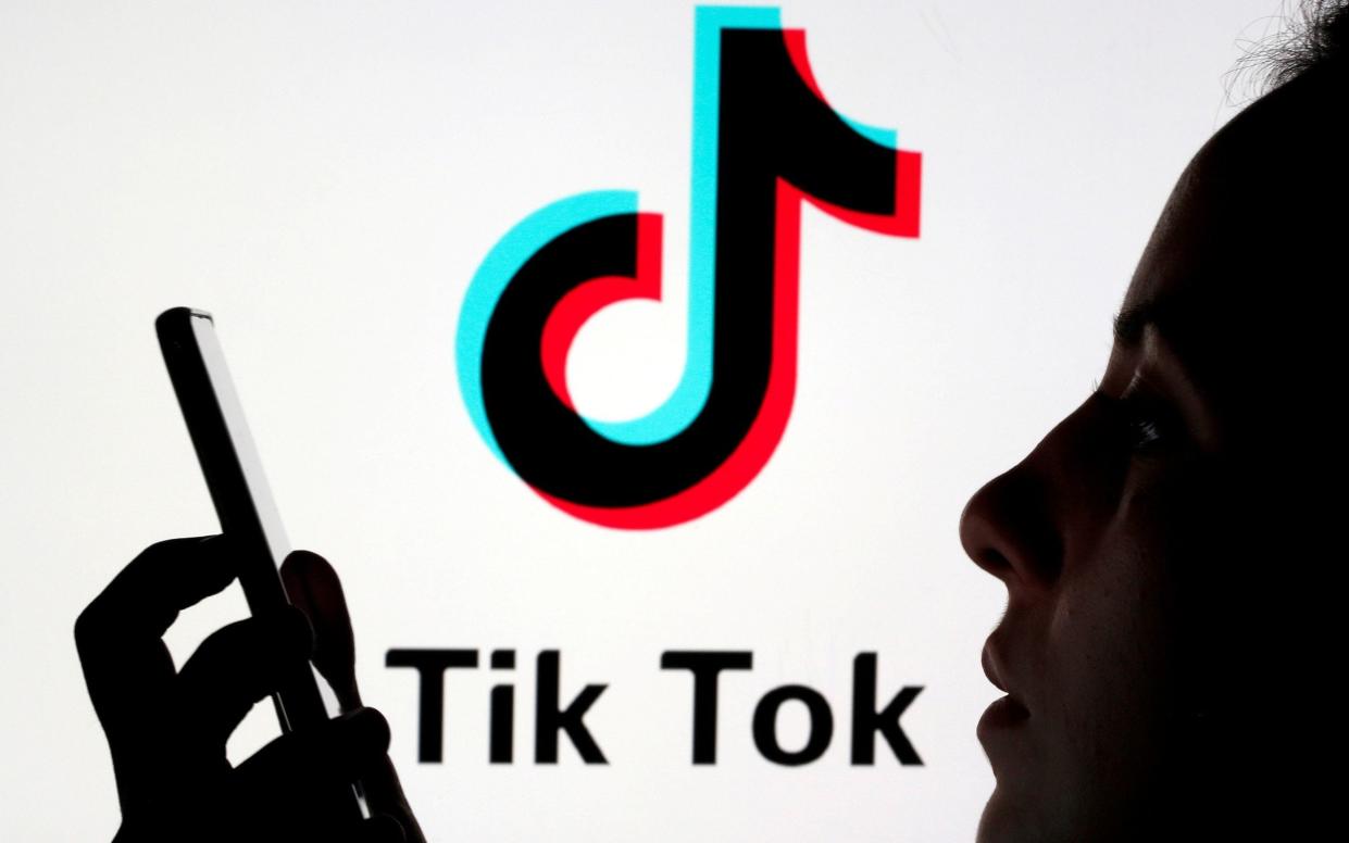 A person holds a smartphone as Tik Tok logo is displayed - Dado Ruvic /REUTERS