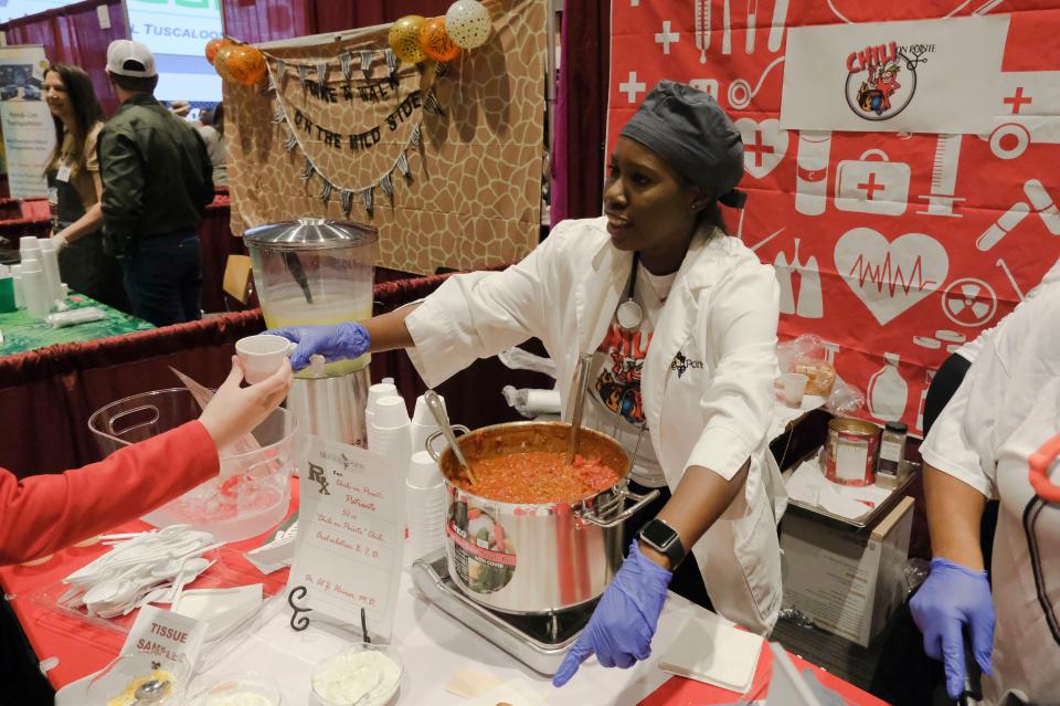 Feb 11, 2023; Tuscaloosa, AL, USA;  Kendra Martin serves up chili at the Chili on Pointe booth, an entry of Morning Pointe Assisted Living and Memory Care at The Great Tuscaloosa Chili Cookout at the Bryant Conference Center Saturday. The event is sponsored by the Exchange Club of Tuscaloosa.