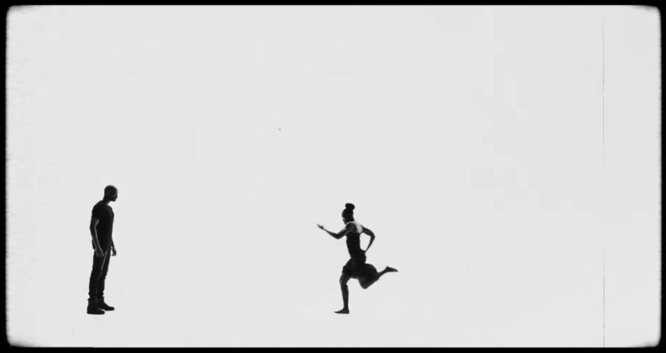 A woman running toward a man against a blank background