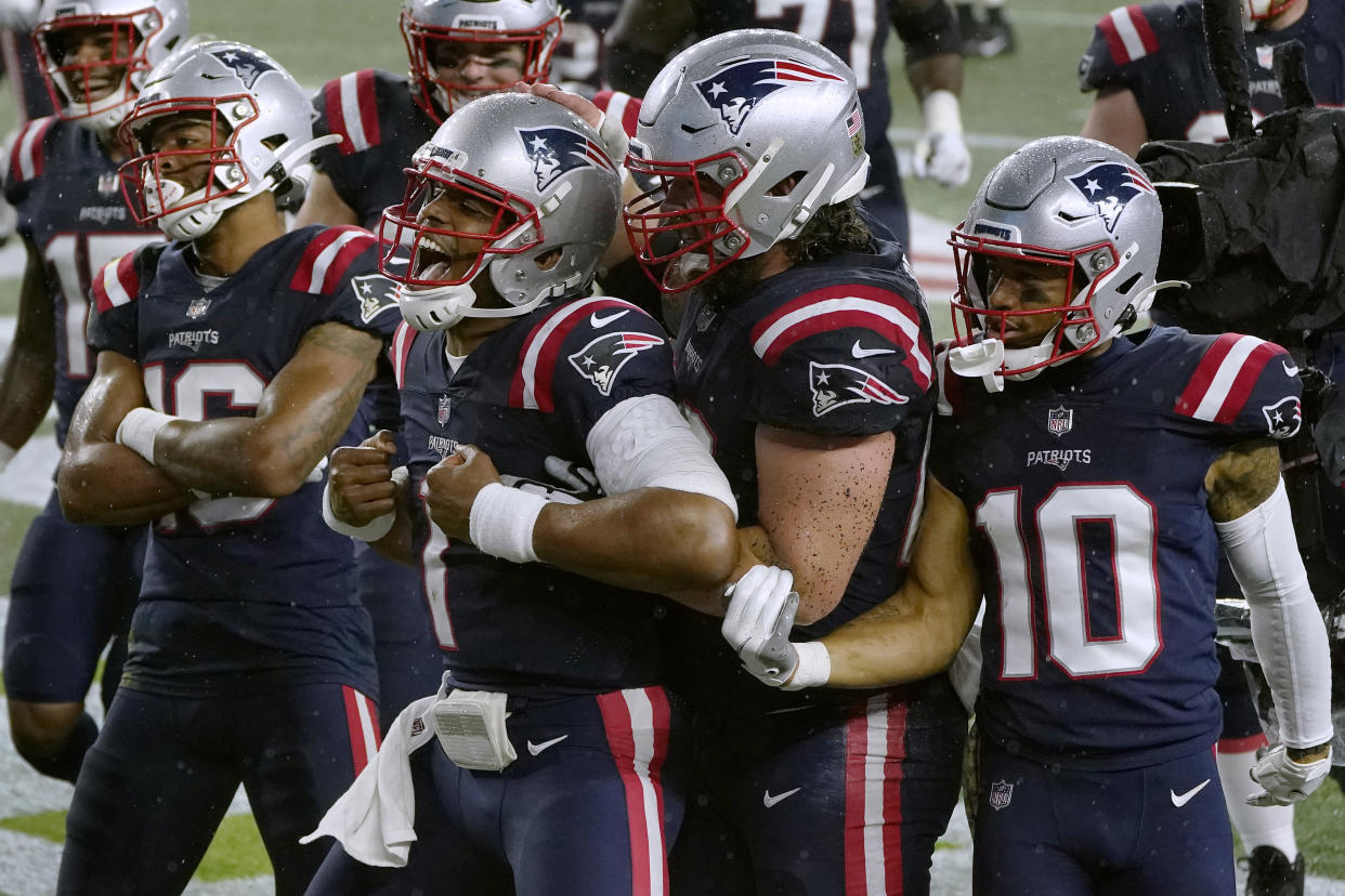 New England Patriots quarterback Cam Newton, center, celebrates his rushing touchdown. (AP Photo/Charles Krupa)