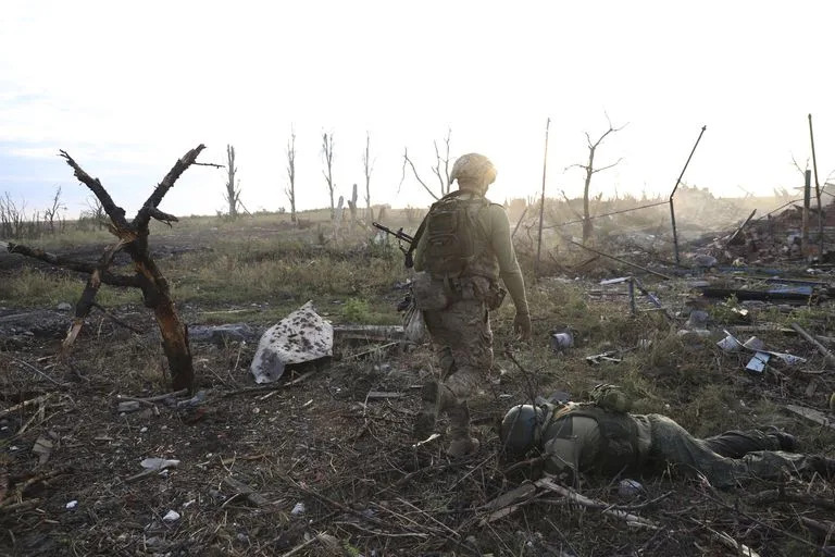 Un comandante ucraniano pasa junto al cuerpo de un soldado ruso muerto en Andriivka, en la región de Donetsk 