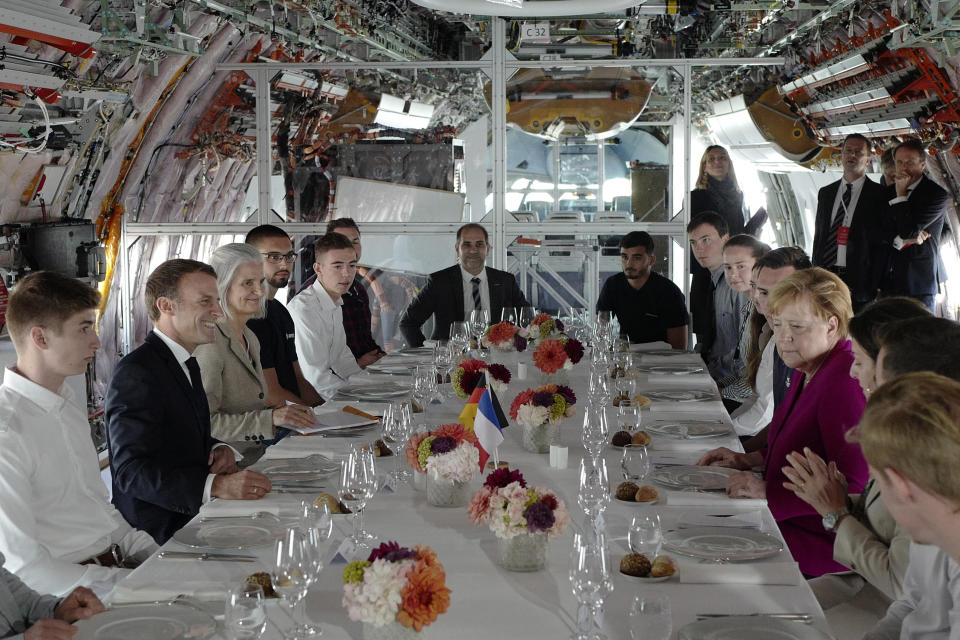 French President Emmanuel Macron, second left, and German Chancellor Angela Merkel, second right, share a lunch with high school children and apprentices in Toulouse, southwestern France, Wednesday, Oct.16, 2019. French President Emmanuel Macron and German Chancellor Angela Merkel are meeting in southern France, one day before a key EU summit that may approve a divorce deal with Britain. (AP Photo/Frederic Scheiber, Pool)