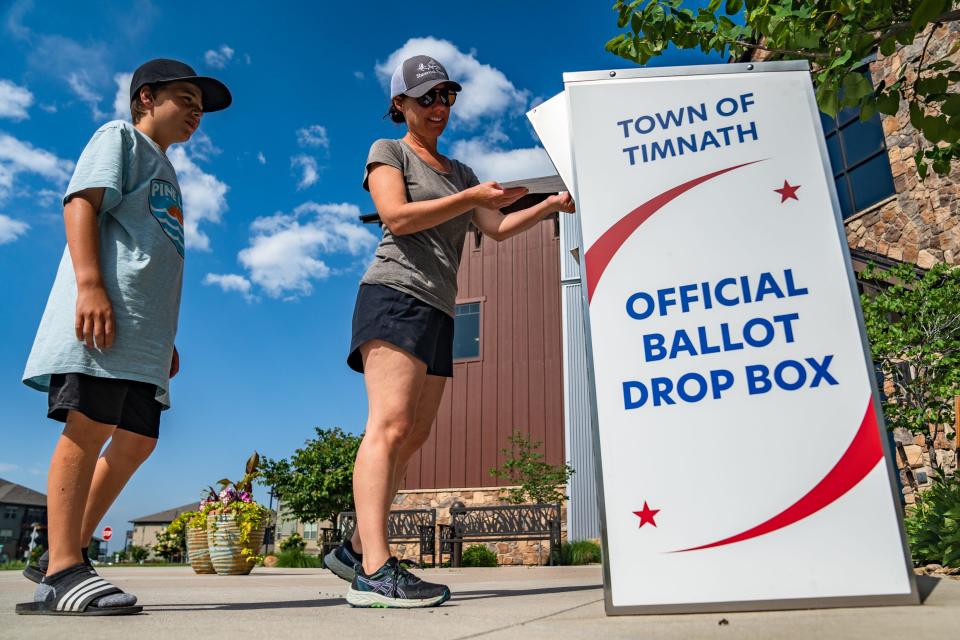 Jen Dekorte drops off a ballot alongside son Miles, 11, at Timnath City Hall on Tuesday in Timnath. Residents voted in a special election on a measure that would effectively prohibit a Topgolf from being built in the Ladera development.