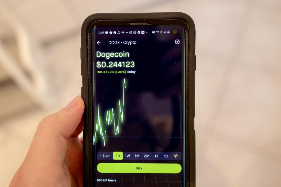 Close-up of person's hand holding smartphone with the Robinhood investment app showing a chart and current price for the cryptocurrency Dogecoin, Lafayette, California, September 15, 2021. (Photo by Smith Collection/Gado/Getty Images)