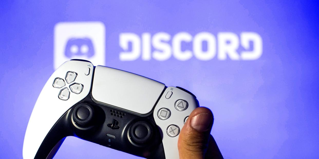 In this photo illustration, a PlayStation 5 controller seen with a Discord logo in the background.