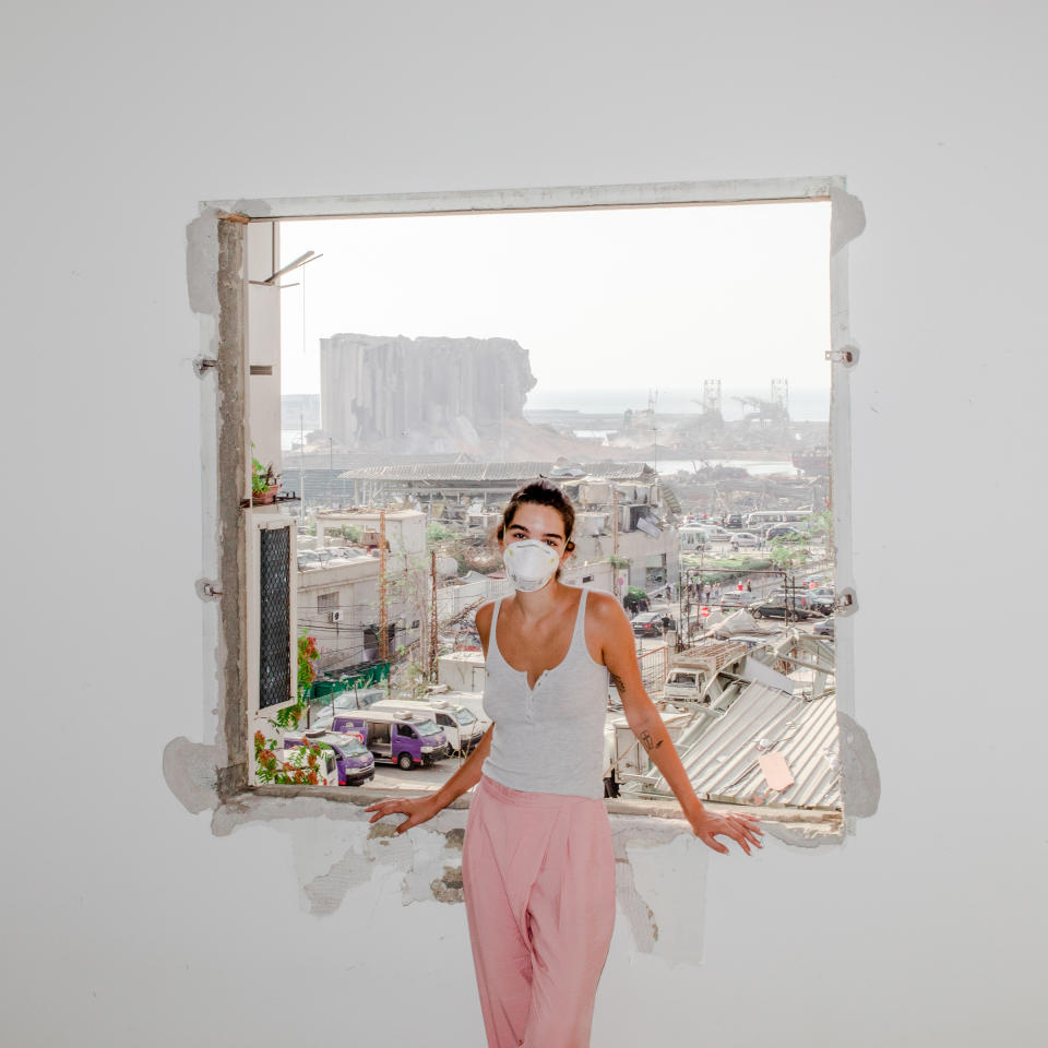 <strong>Nour Saliba</strong> stands in her apartment in the Mar Mikhael area of Beirut on Aug. 6, two days after the deadly explosion at the city’s port, seen through her blown-out window. "<a href="https://time.com/5879192/beirut-explosion-lebanon-reform/" rel="nofollow noopener" target="_blank" data-ylk="slk:After the Explosion;elm:context_link;itc:0;sec:content-canvas" class="link ">After the Explosion</a>," Aug. 31 issue.<span class="copyright">Myriam Boulos for TIME</span>