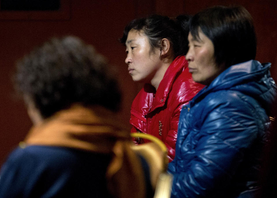 Chinese relatives of passengers aboard a missing Malaysia Airlines plane wait inside a hotel room in Beijing Monday, March 10, 2014. The anguished hours had turned into a day and a half. Fed up with awaiting word on the missing plane, relatives of passengers in Beijing lashed out at the carrier with a handwritten ultimatum and an impromptu news conference. (AP Photo/Andy Wong)