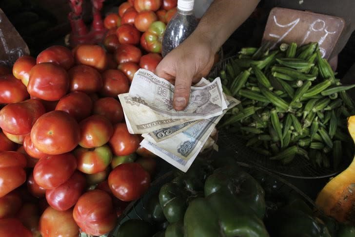 FOTO DE ARCHIVO. Un hombre muestra billetes de peso cubano en un mercado de agricultores en La Habana, Cuba