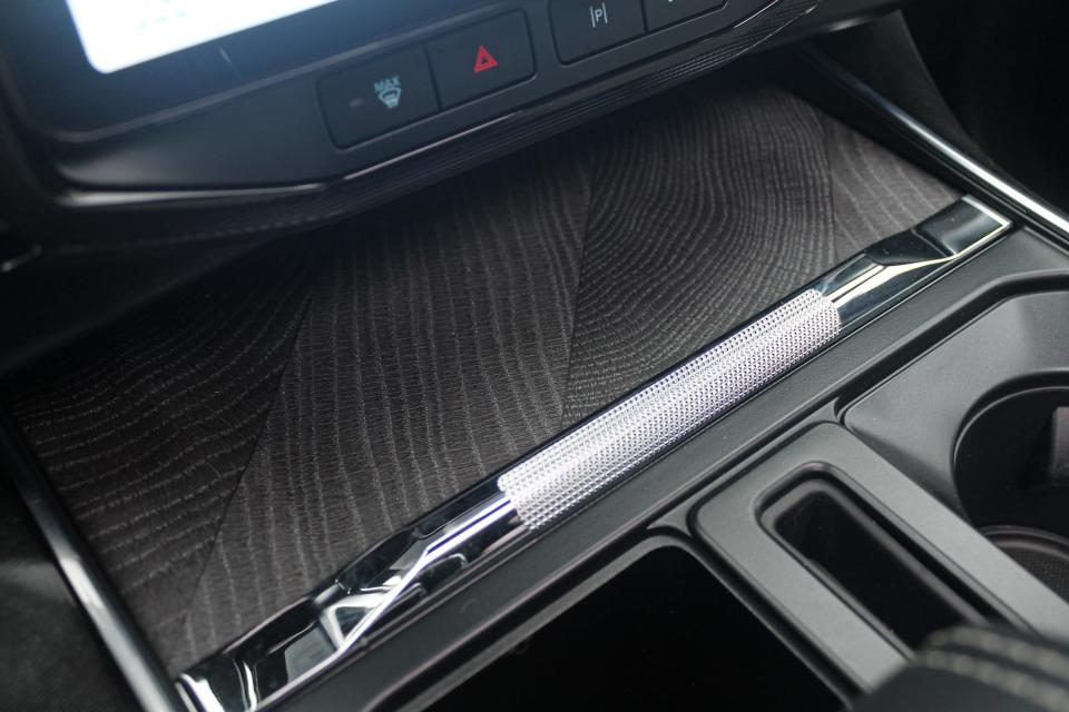 A dark, wood-grain piece of trim in the center console of the 2023 Ford F-150 Lightning Platinum.