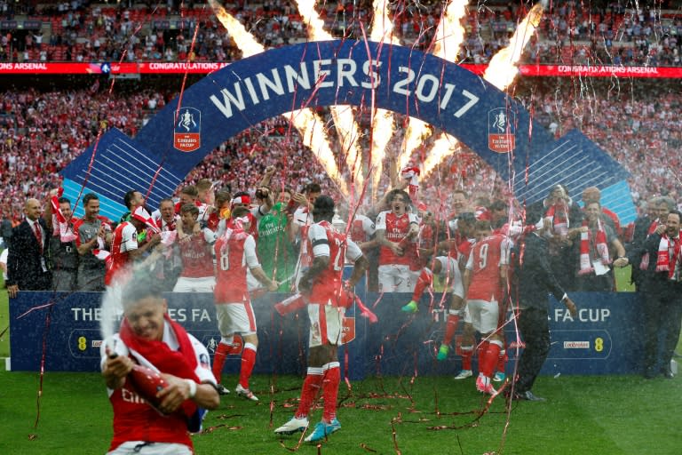 Arsenal's Alexis Sanchez sprays champagne as the team celebrates their win over Chelsea on the pitch after their English FA Cup final at Wembley stadium in London on May 27, 2017