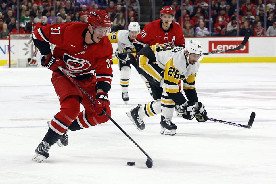 Carolina Hurricanes' Andrei Svechnikov (37) controls the puck with teammate Sebastian Aho (20) and Pittsburgh Penguins' Marcus Pettersson (28) nearby during the second period of an NHL hockey game in Raleigh, N.C., Saturday, Jan. 13, 2024. (AP Photo/Karl B DeBlaker)