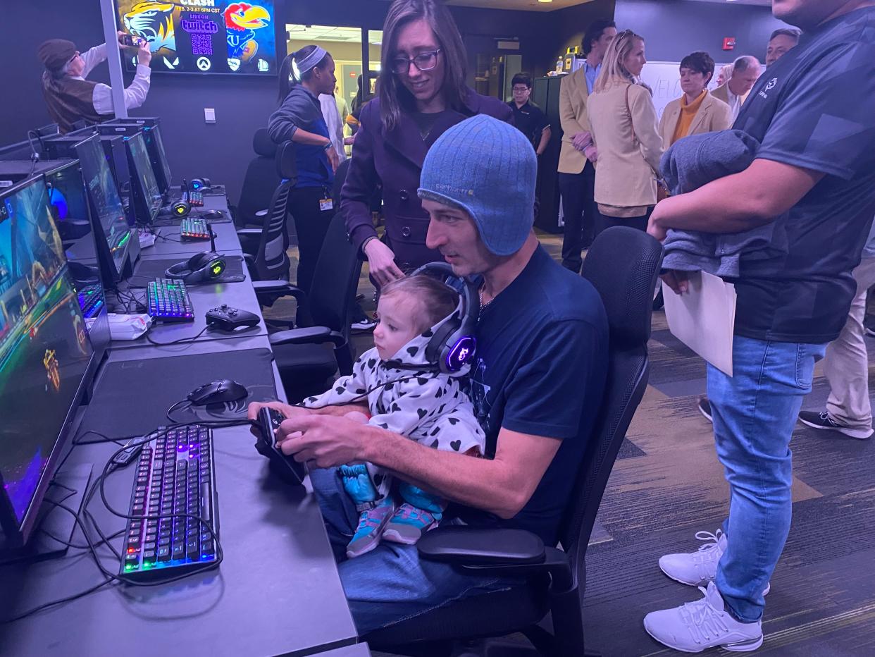 Nick Defauw is assisted by 2-year-old daughter Jocelyn as wife and mother Amber Defauw watches on Thursday, Feb. 2, 2023, in the new University of Missouri eSports Gaming Lounge in Center Hall.