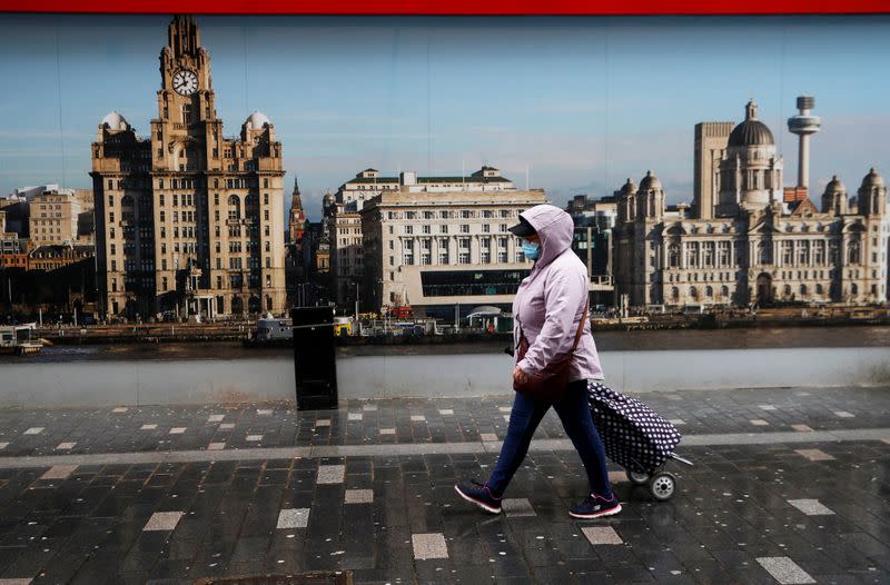 FILE PHOTO: A woman wearing a face mask walks on the street in Liverpool