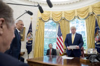 President Donald Trump holds a letter presented to him by Chinese Vice Premier Liu He, second from left, in the Oval Office of the White House in Washington, Friday, Oct. 11, 2019. Also pictured is U.S. Trade Representative Robert Lighthizer, left. (AP Photo/Andrew Harnik)