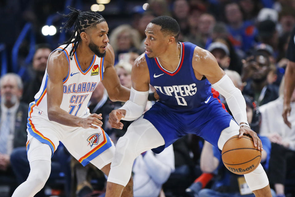 Los Angeles Clippers guard Russell Westbrook (0) dribbles the ball as Oklahoma City Thunder guard Isaiah Joe (11) defends during the first half of an NBA basketball game Thursday, Dec. 21, 2023, in Oklahoma City. (AP Photo/Nate Billings)