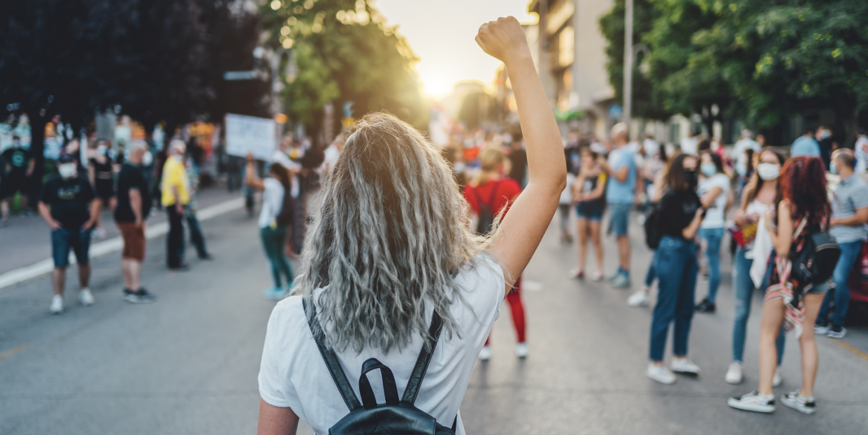 woman raises fist at rally