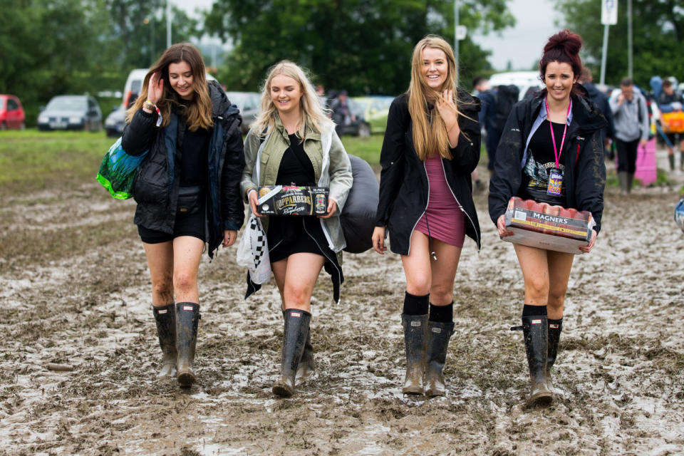 Here come the girls: Glasto fans are all smiles despite the weather. (SWNS)