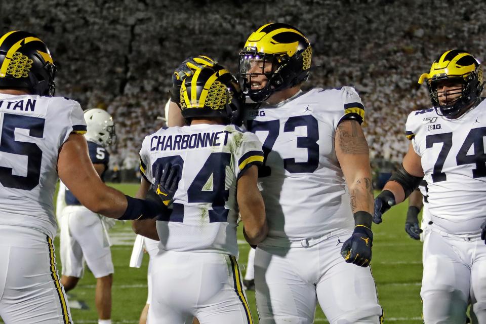 Michigan running back Zach Charbonnet celebrates his touchdown with Jalen Mayfield (73) during the first half against Penn State in State College, Pa., Saturday, Oct. 19, 2019.