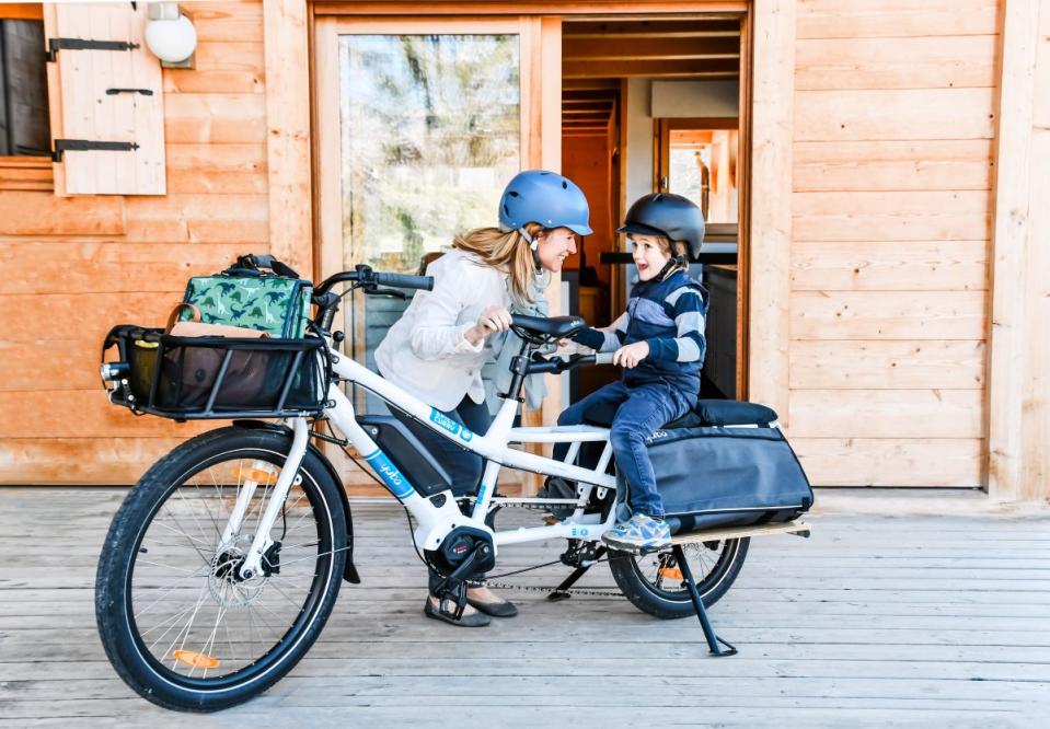 Yuba Spicy Curry e-cargo bike. Mom gets kid ready to ride.