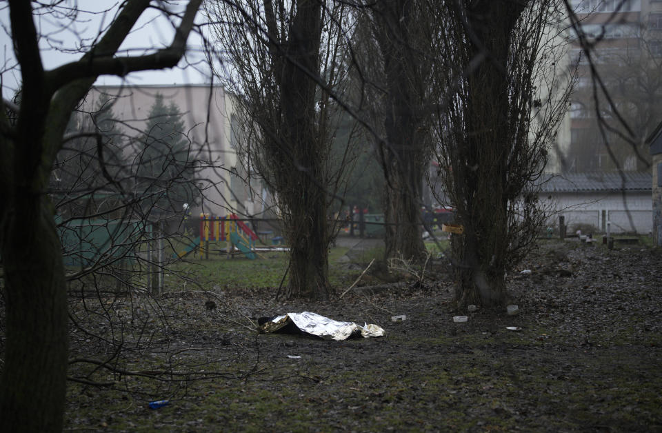 A dead body on the ground at the scene where a helicopter crashed on civil infrastructure in Brovary, on the outskirts of Kyiv, Ukraine, Wednesday, Jan. 18, 2023. The chief of Ukraine's National Police says a helicopter crash in a Kyiv suburb has killed 16 people, including Ukraine's interior minister and two children. He said nine of those killed were aboard the emergency services helicopter. (AP Photo/Daniel Cole)