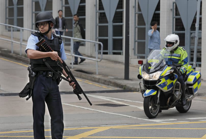 A police officer stands guard while a prison bus carrying Interpol-wanted suspect Ramanjit Singh leaving a Magistrate's court in Hong Kong, 2 March 2018