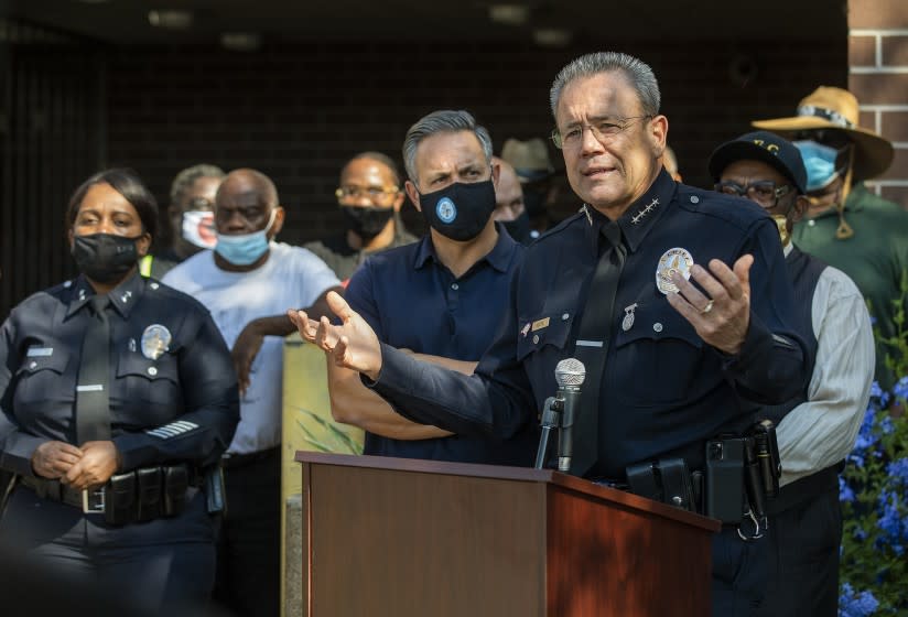 LAPD Police Chief Michel Moore, right, addresses the media outside the Southeast Community Police Station