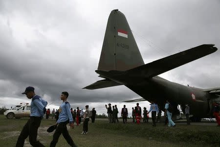 Search and Rescue team members walk near a Hercules C-130, as they wait for better weather conditions to take off for their search operation for the AirAsia flight QZ8501, at Iskandar airbase in Pangkalan Bun district, Indonesia, December 31, 2014. REUTERS/Beawiharta