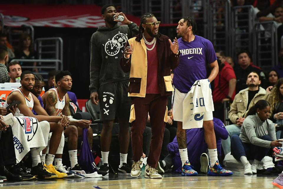 Apr 6, 2022; Los Angeles, California, USA; Phoenix Suns forward Jae Crowder (center) and center Deandre Ayton (left) watch game action against the Los Angeles Clippers during the first half at Crypto.com Arena.