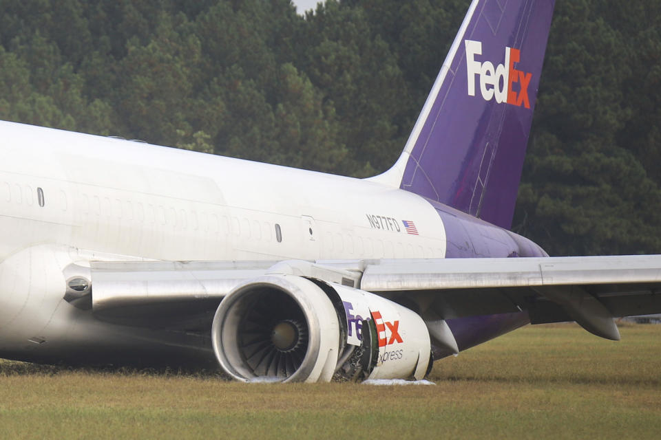 A FedEx 757 sits on a landing strip Thursday, Oct. 5, 2023 at the Chattanooga Metropolitan Airport after crash landing late Wednesday evening. Officials say the FedEx plane skidded off the runway during a crash landing when its landing gear did not descend, but no one was injured. (Olivia Ross /Chattanooga Times Free Press via AP)