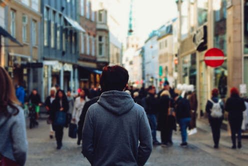 <span class="caption">Nearly half of people in the UK report experiencing loneliness. </span> <span class="attribution"><a class="link " href="https://www.shutterstock.com/image-photo/urban-man-standing-turn-around-crowd-726870622" rel="nofollow noopener" target="_blank" data-ylk="slk:Ton Kung/ Shutterstock;elm:context_link;itc:0;sec:content-canvas">Ton Kung/ Shutterstock</a></span>