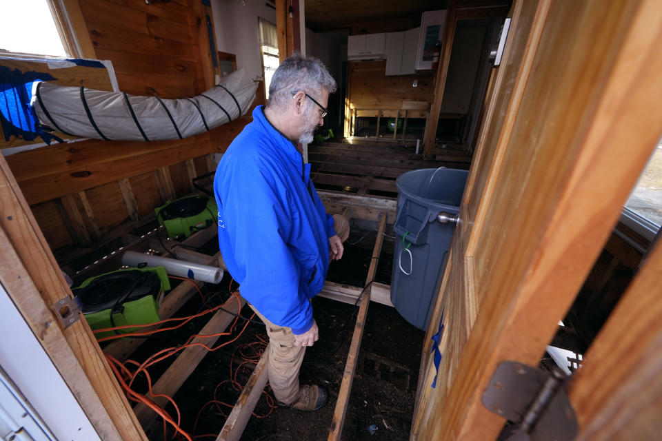 Haim Levy stands in his cottage near Hampton Beach, which was flood damaged during January 2024 storms, Friday, Feb. 9, 2024, in Hampton, N.H. Scientists say the back-to-back storms that lashed the Northeast in January were more of a sign of things to come than an anomaly. Many scientists who study the intersection of climate change, flooding, winter storms and sea level say such storms will arrive with increased frequency and ferocity. (AP Photo/Charles Krupa)