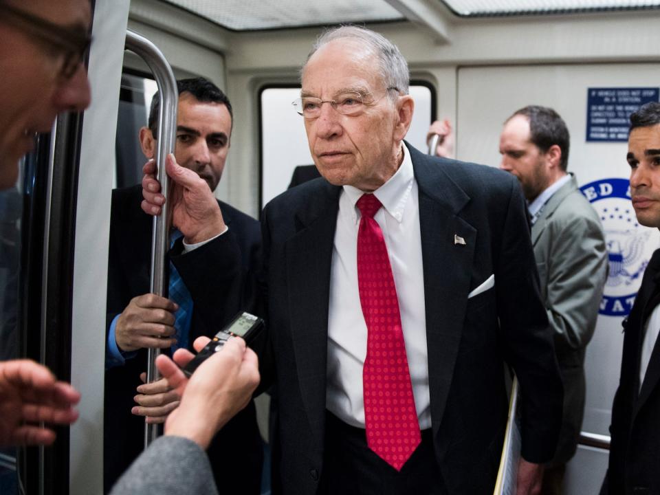 Republican Sen. Chuck Grassley takes questions from congressional reporters while standing in the doorway of an automated Senate subway train in April 2019.