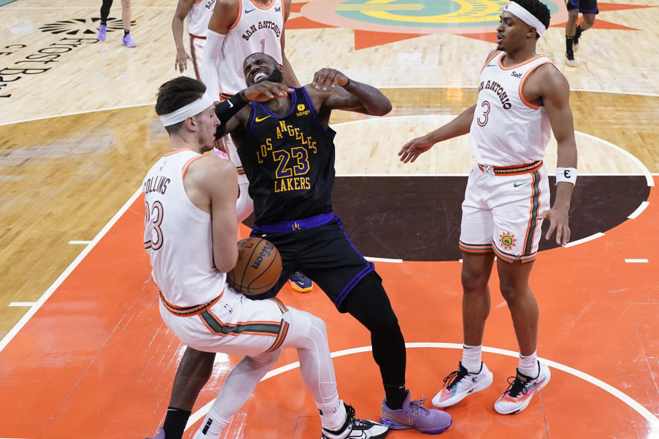 Los Angeles Lakers forward LeBron James (23) is fouled by San Antonio Spurs forward Zach Collins (23) during the first half of an NBA basketball game in San Antonio, Friday, Dec. 15, 2023. (AP Photo/Eric Gay)