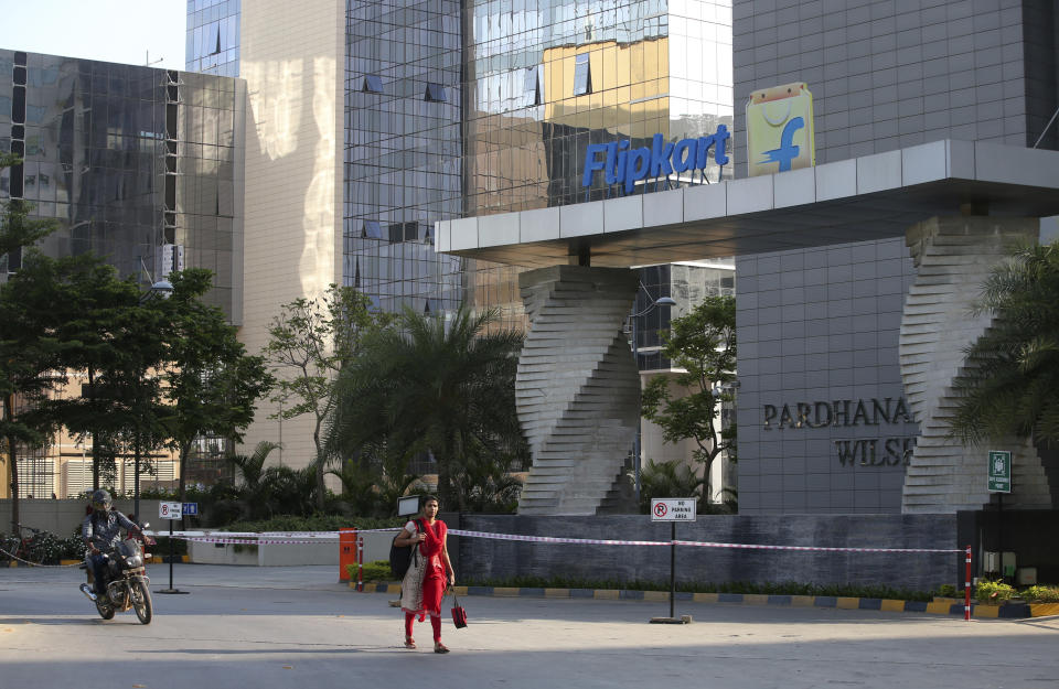 A motorist and a woman walks past a building that formerly was the Flipkart headquarters in Bangalore, India, Wednesday, May 9, 2018. (AP Photo/Aijaz Rahi) (Photo: ASSOCIATED PRESS)