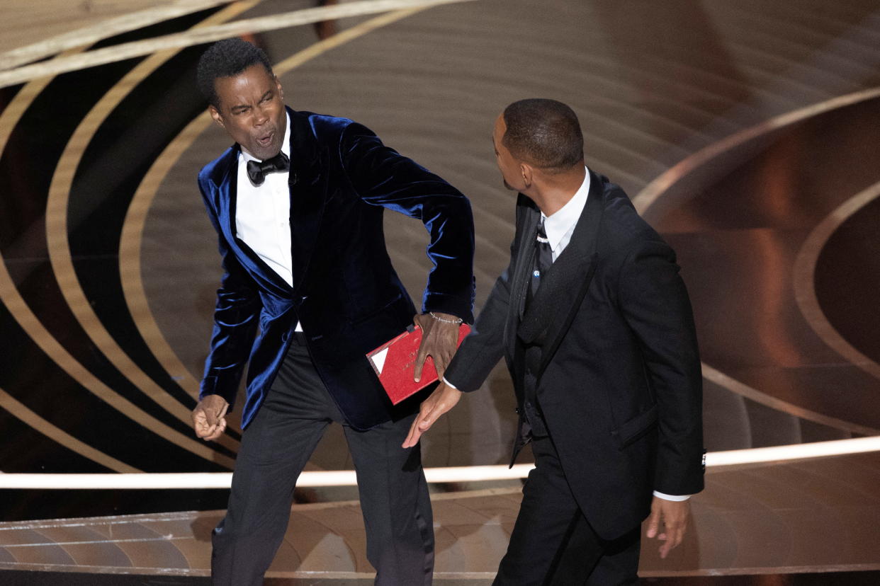 Chris Rock reacts after being hit by Will Smith (R) as Rock spoke on stage during the 94th Academy Awards in Hollywood, Los Angeles, California, U.S., March 27, 2022. Picture taken March 27, 2022. REUTERS/Brian Snyder BEST AVAILABLE QUALITY
