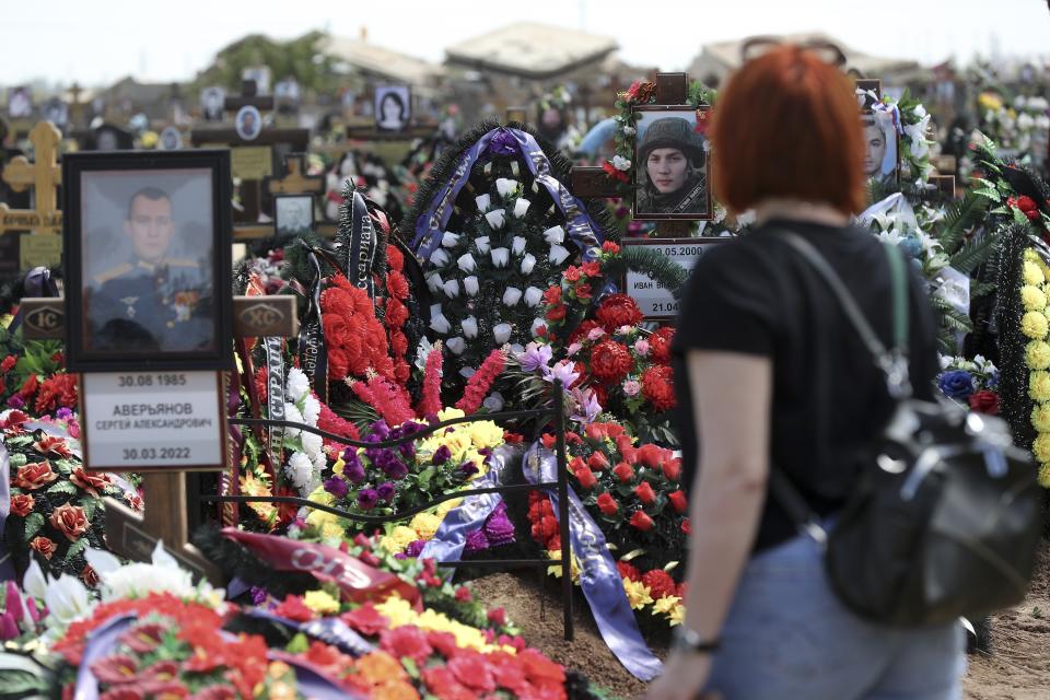 A woman looks at the graves of Russian soldiers at a cemetery in Volzhsky, outside Volgograd, Russia, Thursday, May 26, 2022. The Russian military has so far confirmed just over 6,000 deaths among its troops in Ukraine. Western estimates put the number much higher – in the tens of thousands. (AP Photo, File)