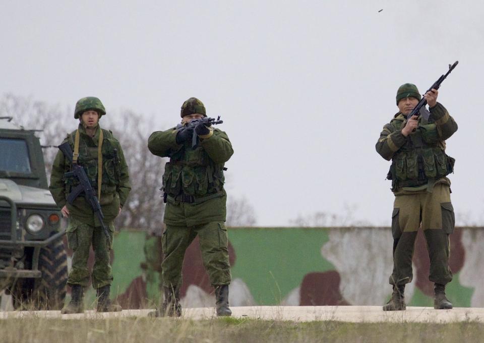 Russian soldiers fire warning shots at the Belbek air base, outside Sevastopol, Ukraine, on Tuesday, March 4, 2014. Russian troops, who had taken control over Belbek airbase, fired warning shots in the air as around 300 Ukrainian officers marched towards them to demand their jobs back. (AP Photo/Ivan Sekretarev)