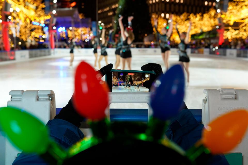JJ Cady, of Royal Oak, records a Iive skating show during the 19th annual Detroit Tree Lighting presented by the DTE Foundation on Friday, Nov. 18, 2022, at Campus Martius Park in downtown Detroit.