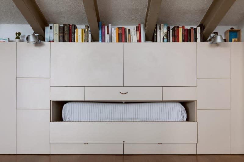 Bed in modular wall unit in neutral toned room.