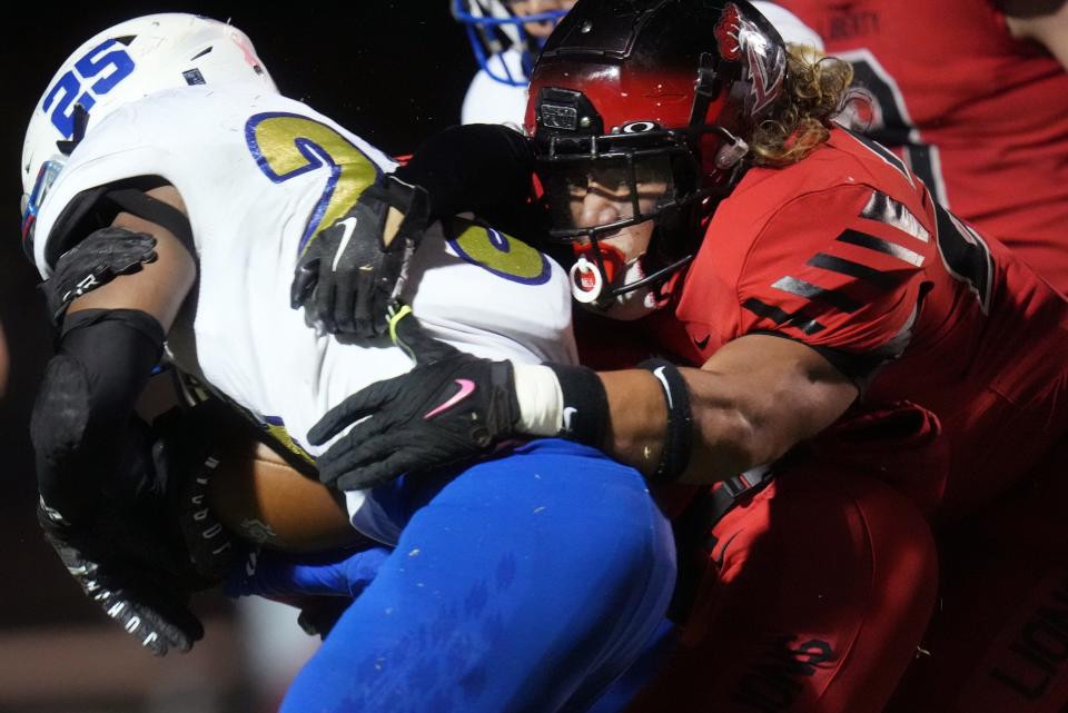 Liberty Lions linebacker Anthony Ruiz (22) tackles Sandra Day O’Connor Eagles running back Kaden Armstrong (25) during their open division playoff game on Friday, Nov. 25, 2022. 